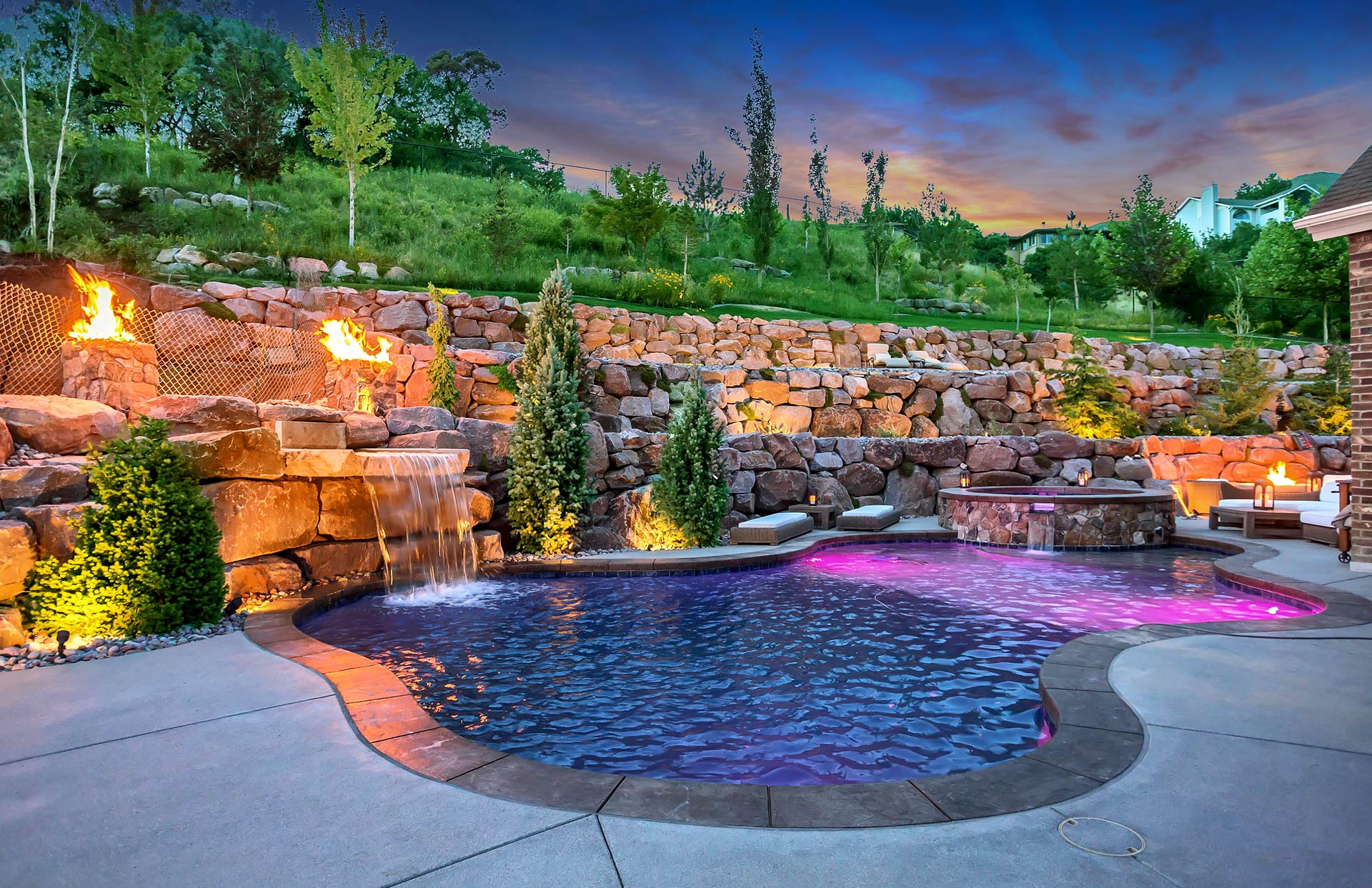 Rock water feature, rock hot tub, swimming pool, stone terraced wall and fire pit