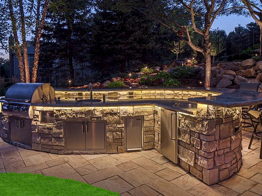 Built in stone kitchen with stone bar on a flagstone patio